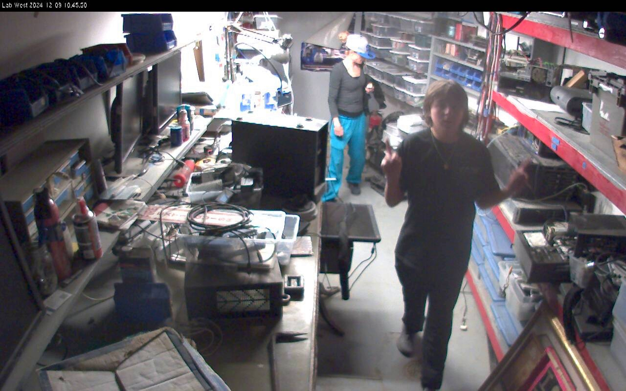 Security camera view of workshop or repair shop interior with shelving and equipment